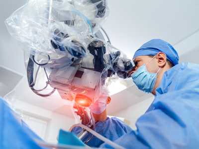operation-through-microscope-surgeons-use-medical-instruments-while-perform-operation-specialists-looking-into-microsco